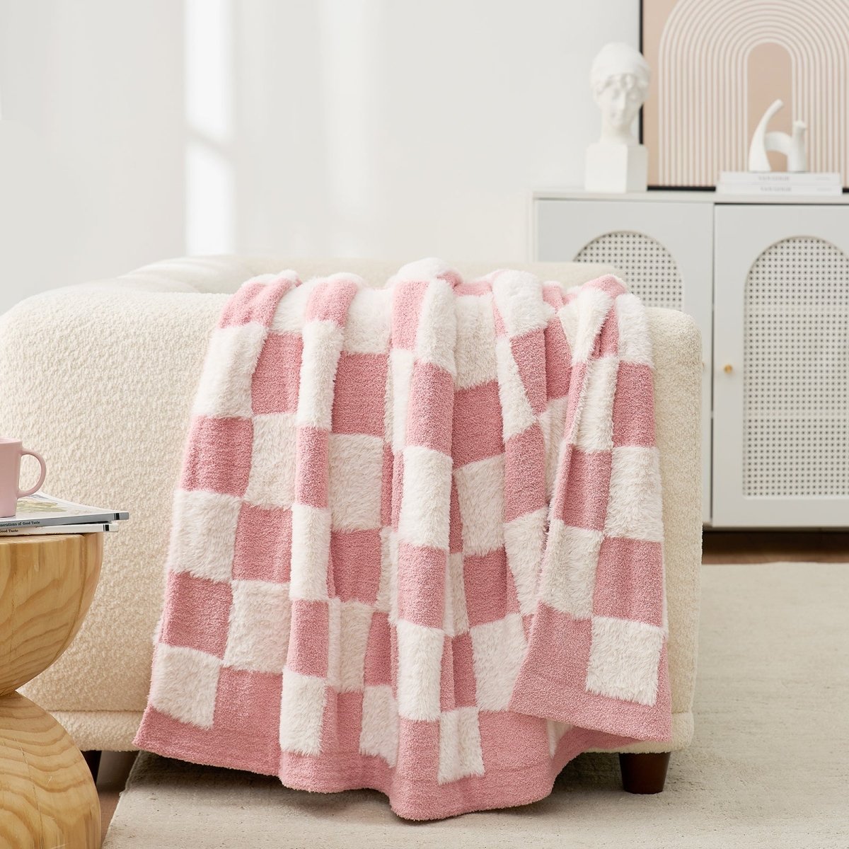 Checkered Faux Fur Feather Yarn Throw Blanket in Pink White draped over a sofa, highlighting its gentle tone and texture. #Color_Pink white