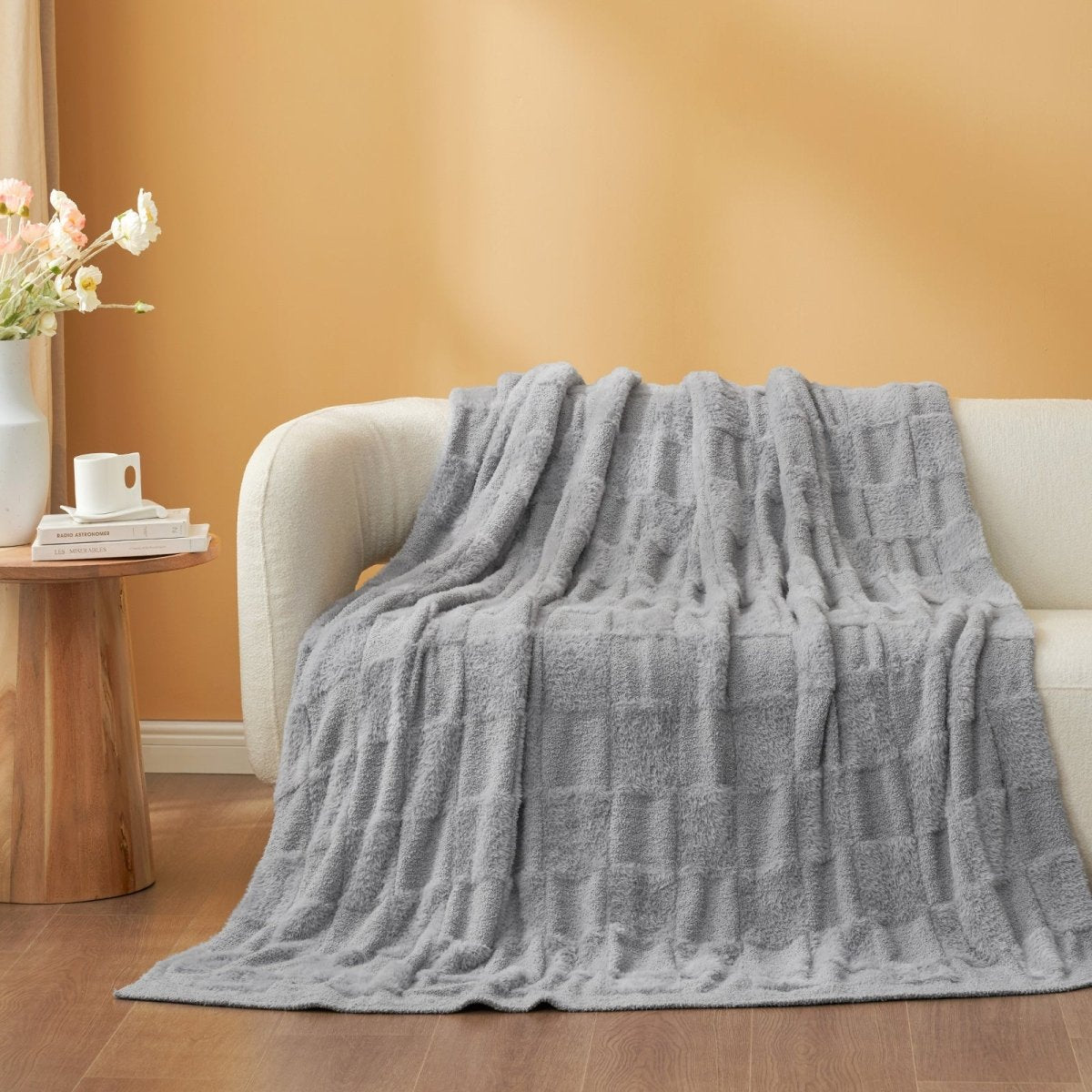 Checkered Faux Fur Feather Yarn Throw Blanket in Light Grey draped over a sofa, highlighting its sleek look. #Color_Light Grey