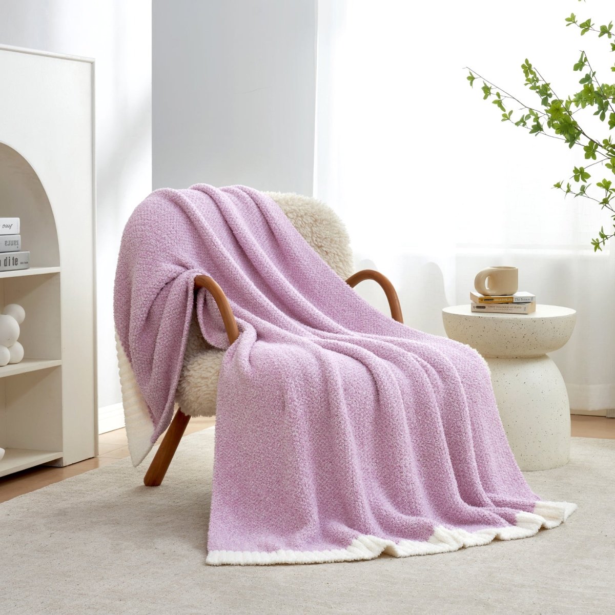 Heather Feather Yarn Throw Blanket in Purple draped over an armchair, creating a warm atmosphere. #color_Purple