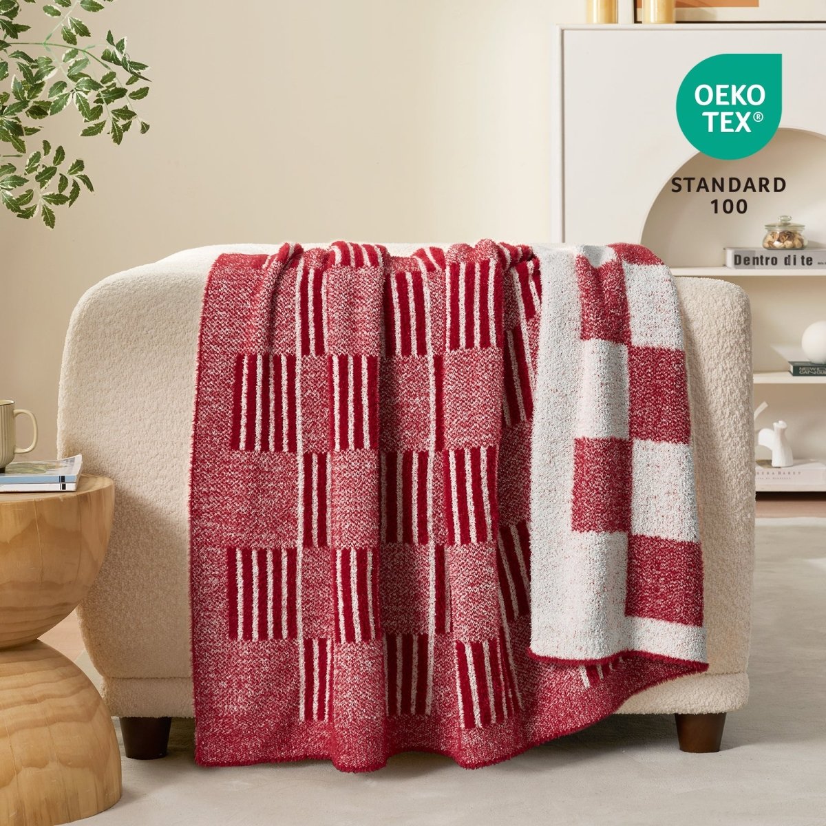 Reversible Heather Checkered Feather Yarn Throw Blanket in Red draped over a sofa, showcasing its soft texture, checkered pattern and OEKO-TEX STANDARD 100 certification. #color_Christmas Red