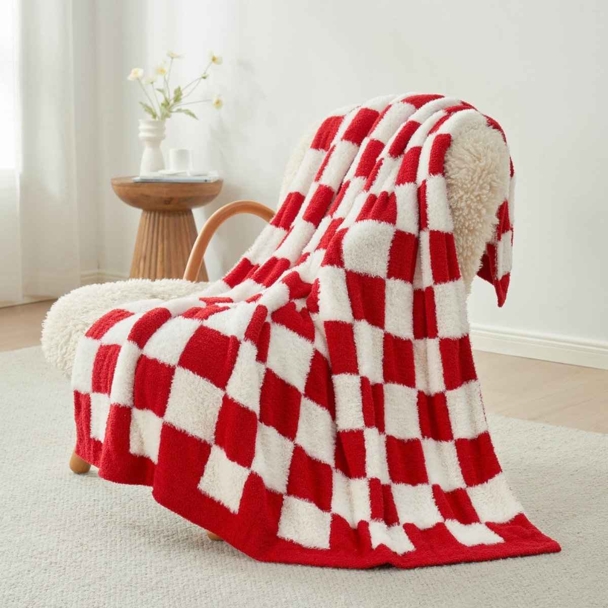 Checkered Faux Fur Feather Yarn Throw Blanket in Red & Cream draped over an armchair, adding warmth and festive style. #color_Red & Cream