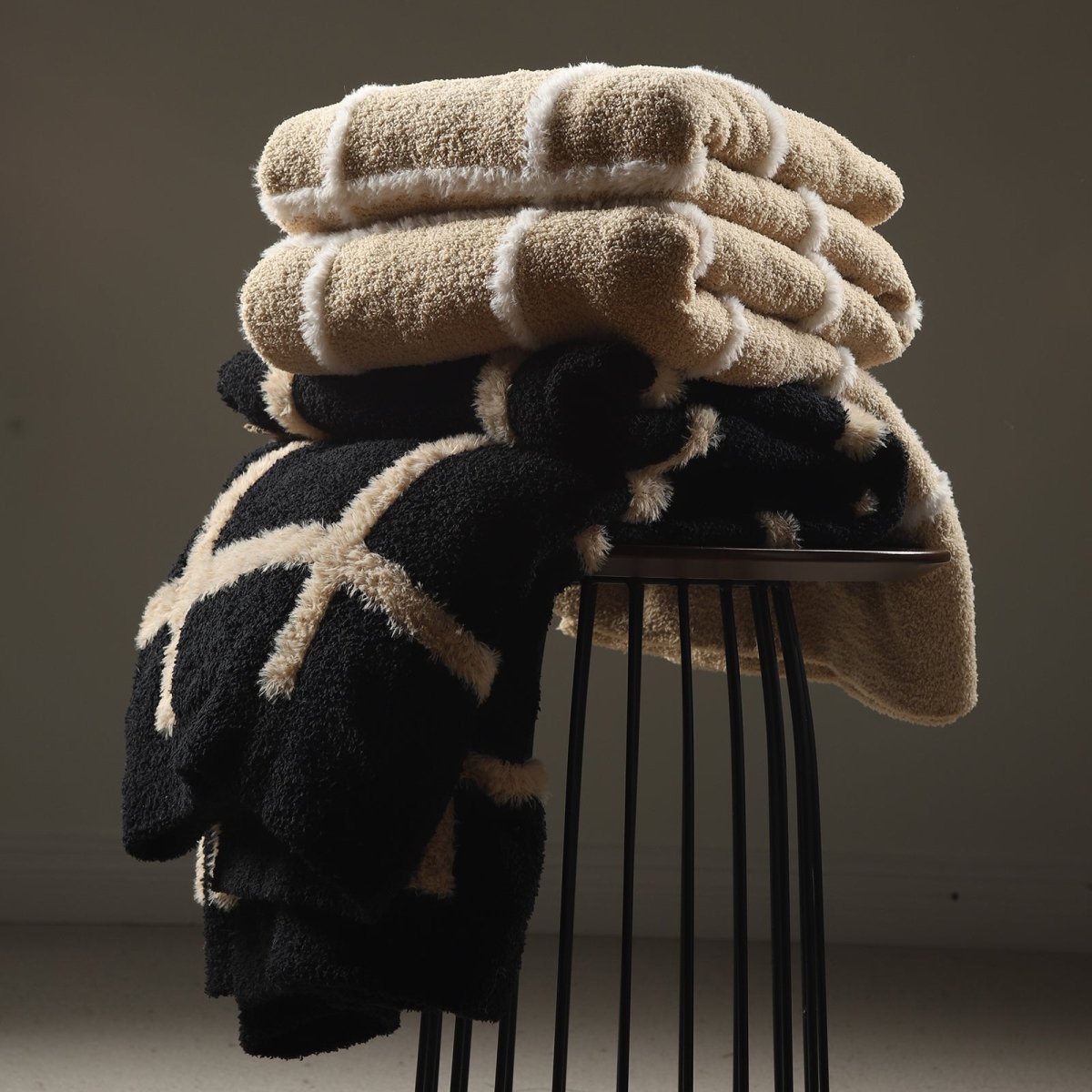 Faux Mink Textured Plaid Knit Throw Blanket in Black neatly stacked on a chair, highlighting soft texture and premium layered look. #color_Black