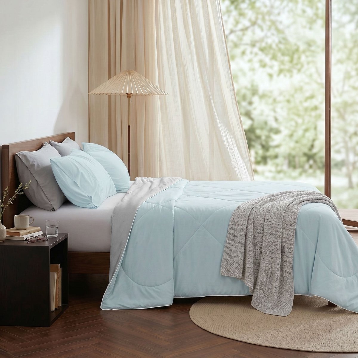Cozy Bliss cooling comforter on bed in side view. Breathable, soft fabric for hot sleepers. #Color_Grey/Blue