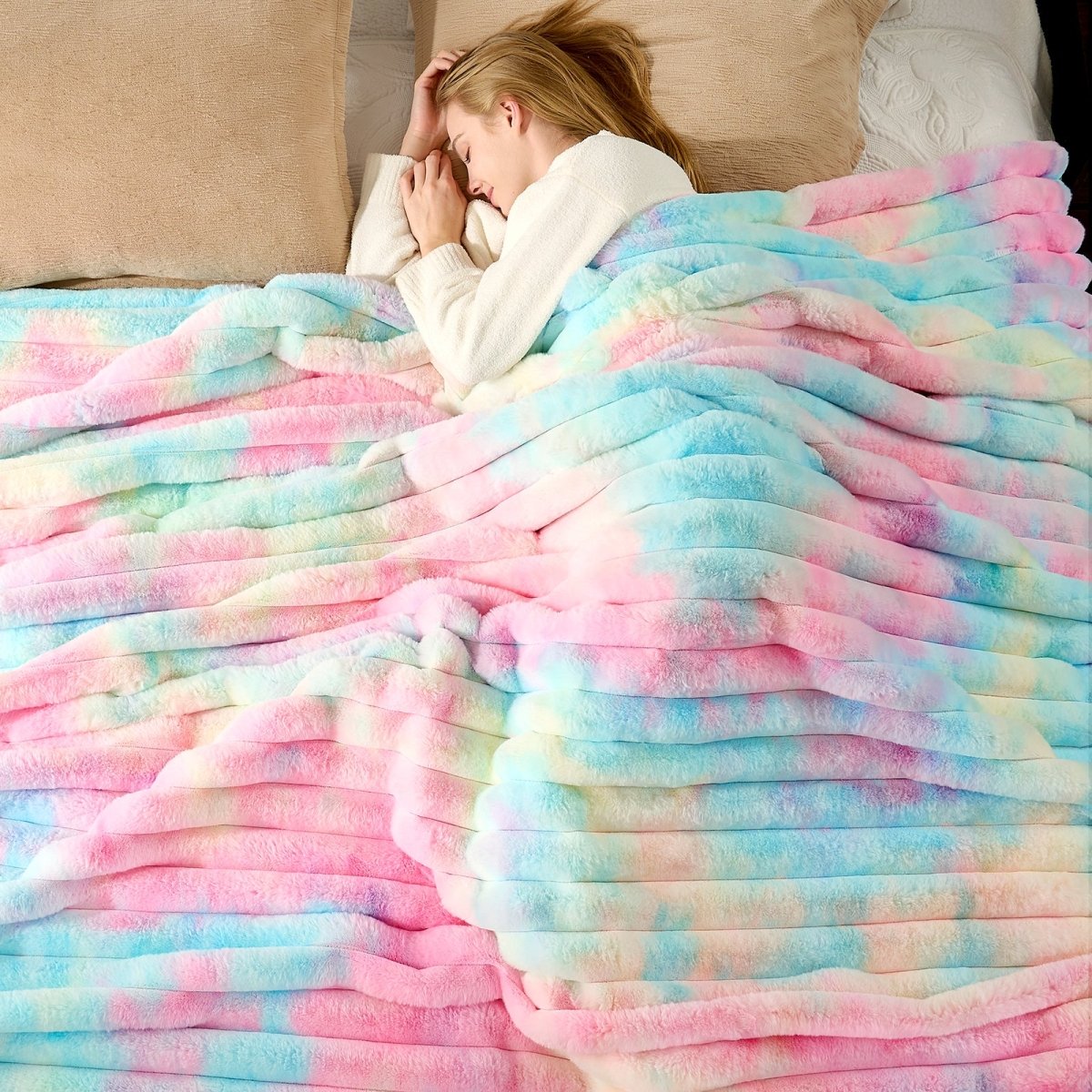Women wrapped in a colorful tie-dye blanket on bed. #color_Tie-dye Rainbow