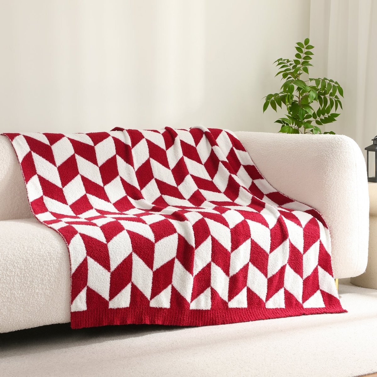 Chevron Feather Yarn Knit Throw Blanket in Red draped over a sofa, creating a warm atmosphere. #color_Christmas Red