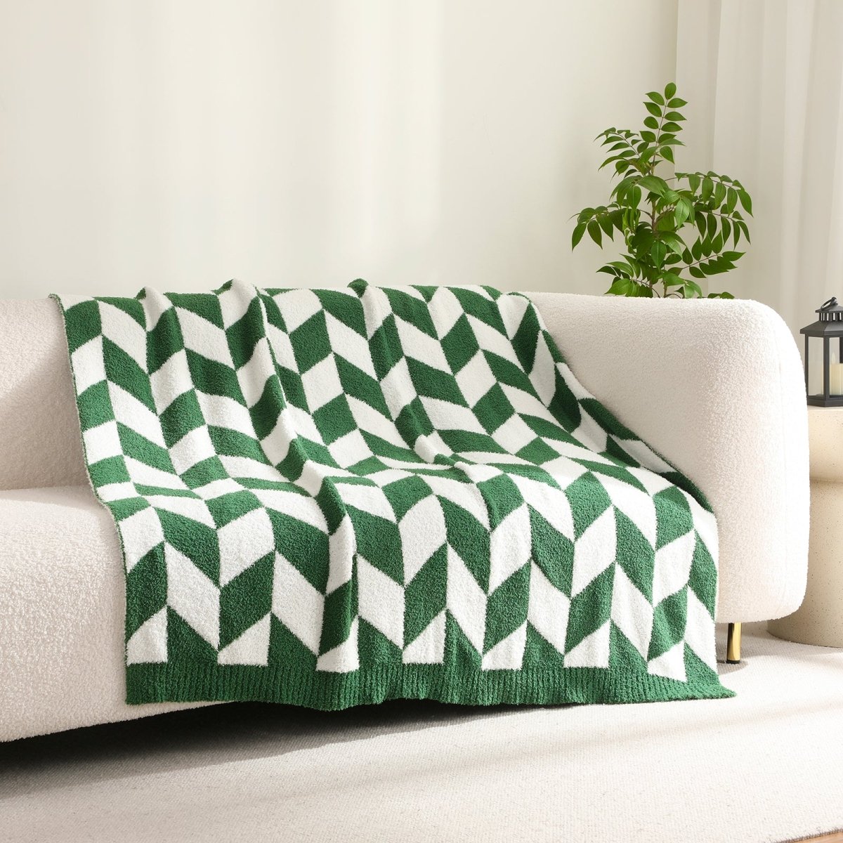 Chevron Feather Yarn Knit Throw Blanket in Xmas Green draped over a sofa, creating a warm atmosphere. #color_Xmas Green