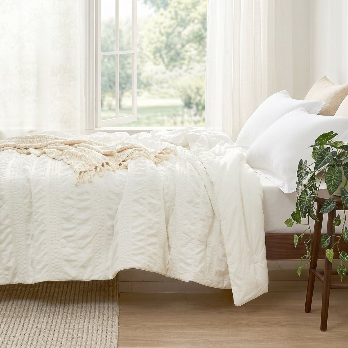 Cozy Bliss seersucker cooling comforter on bed in side view.#color_Cream White
