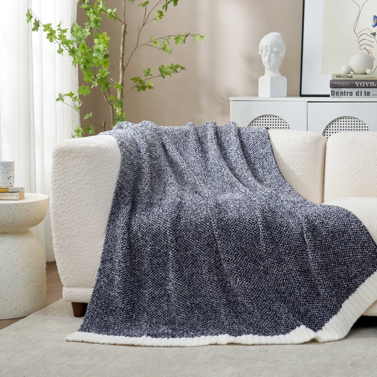 Heather Feather Yarn Throw Blanket in Navy Blue draped over a sofa, adding a deep cozy tone to your living room. #color_Navy Blue
