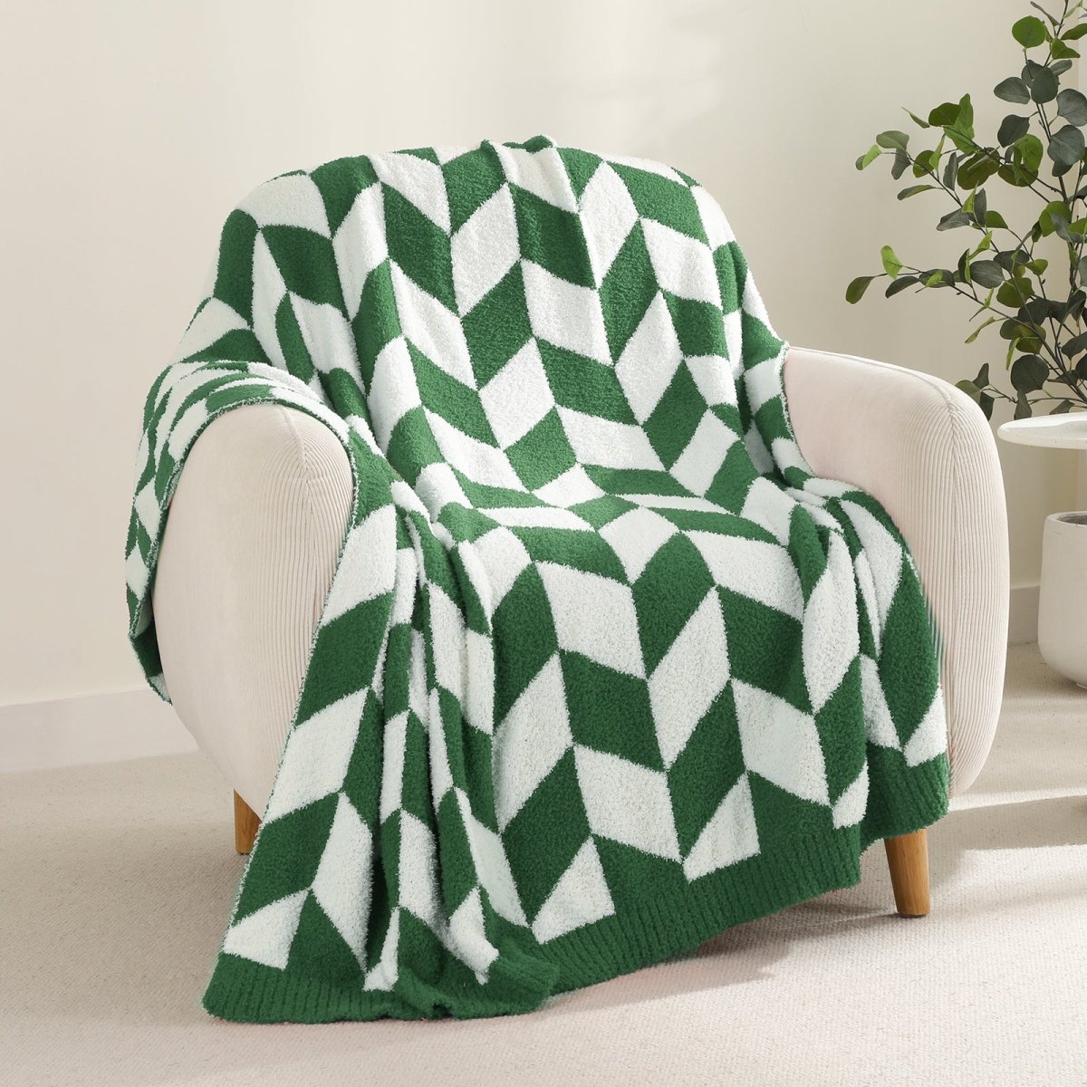 Chevron Feather Yarn Knit Throw Blanket in Green draped over an armchair, showcasing soft feather yarn texture and chevron pattern design. #color_Xmas Green
