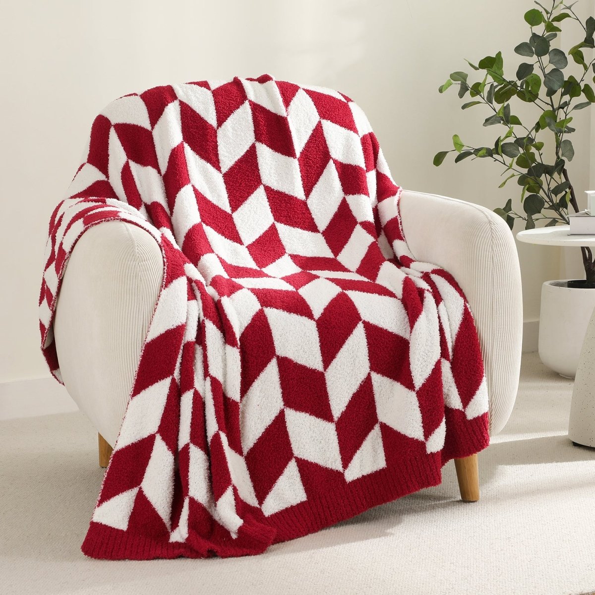 Chevron Feather Yarn Knit Throw Blanket in Red draped over an armchair, showcasing soft feather yarn texture and chevron pattern design. #color_Christmas Red
