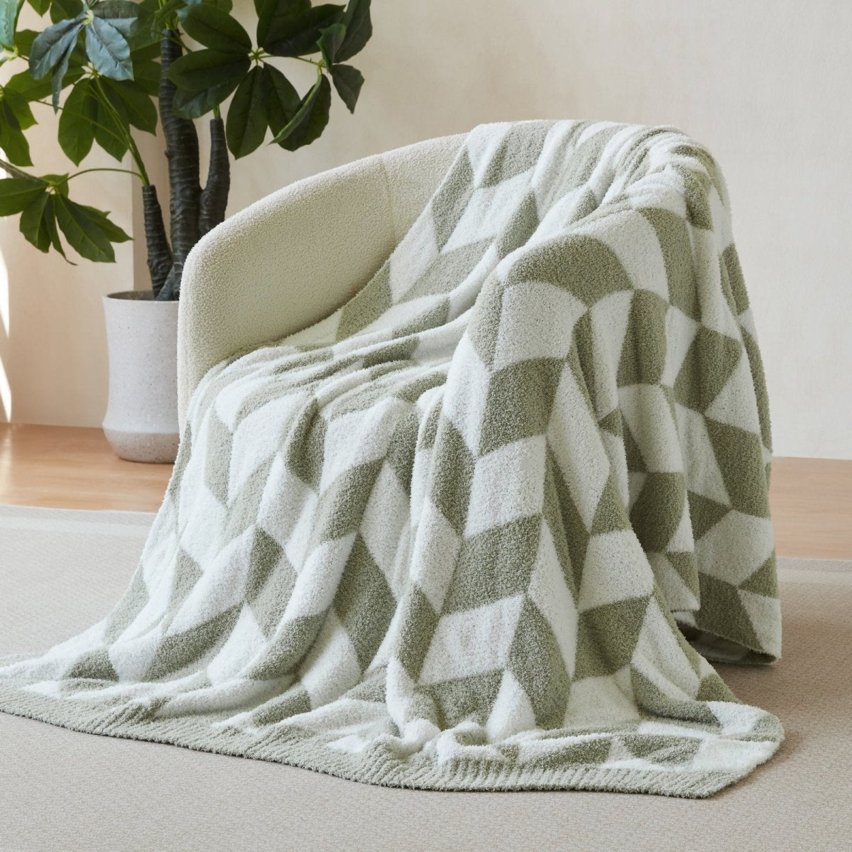 Chevron Feather Yarn Knit Throw Blanket in Sage Green draped over an armchair, showcasing soft feather yarn texture and chevron pattern design. #color_Sage Green
