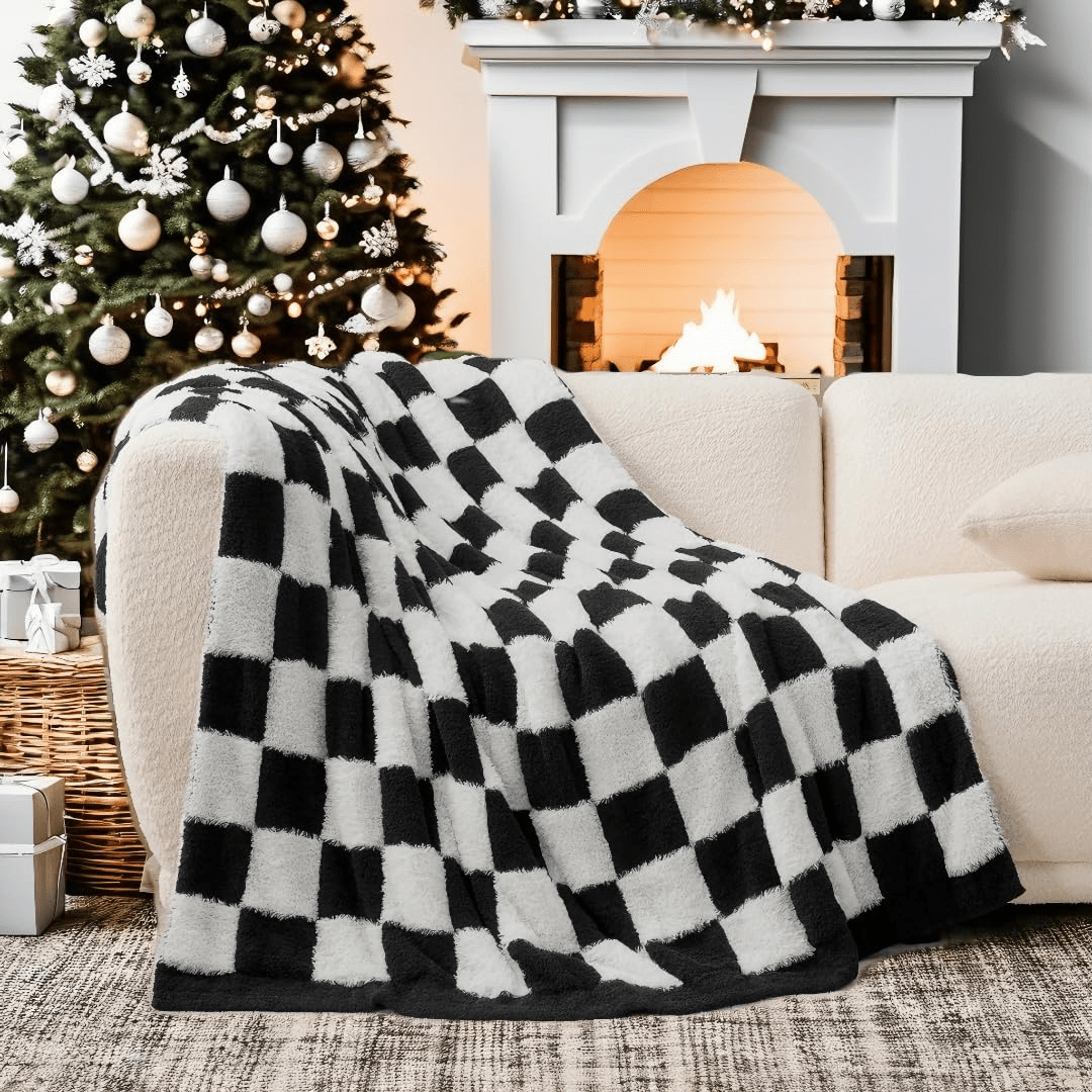 Checkered Faux Fur Feather Yarn Throw Blanket in Black & White draped over a sofa, highlighting its bold design. #color_Black & White