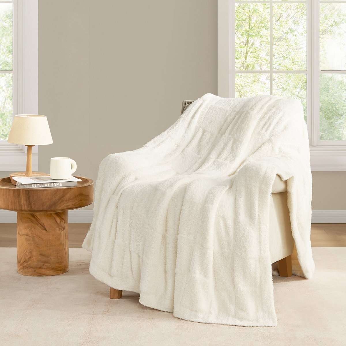 Checkered Faux Fur Feather Yarn Throw Blanket in Ivory draped over a chair, adding a warm and cozy touch to your space. #color_Ivory