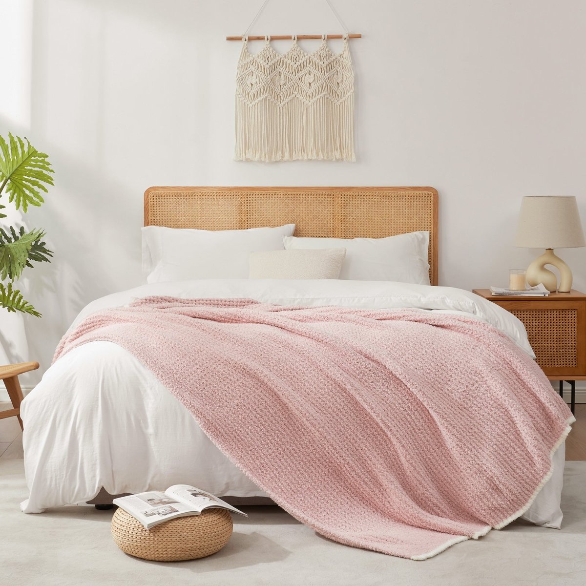 Soft Waffle Feather Yarn Throw Blanket in Pink styled on a bed, adding a soft and cozy layered look. #color_Pink