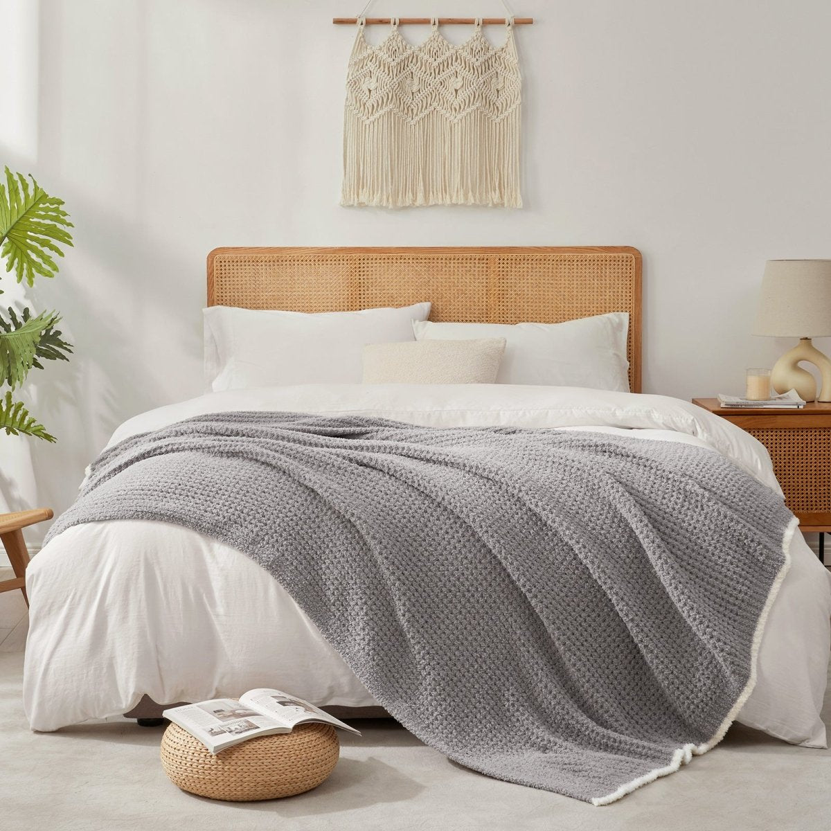 Soft Waffle Feather Yarn Throw Blanket in Grey styled on a bed, adding a modern and cozy layered look. #color_Grey