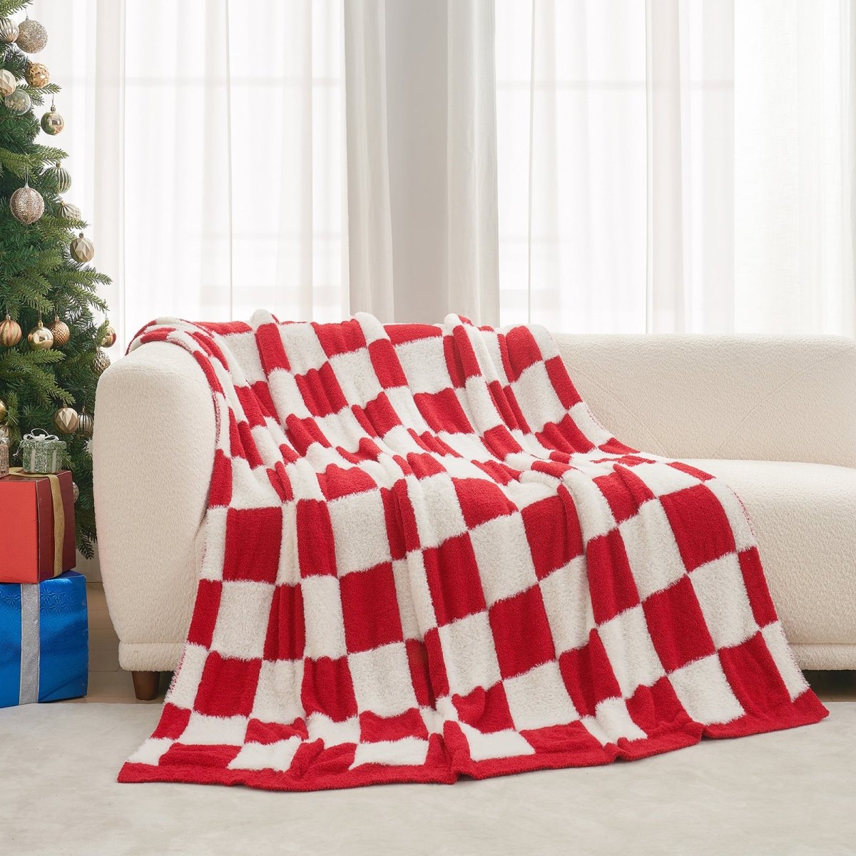 Checkered Faux Fur Feather Yarn Throw Blanket in Red & Cream draped over a sofa, highlighting its checkered design. #color_Red & Cream
