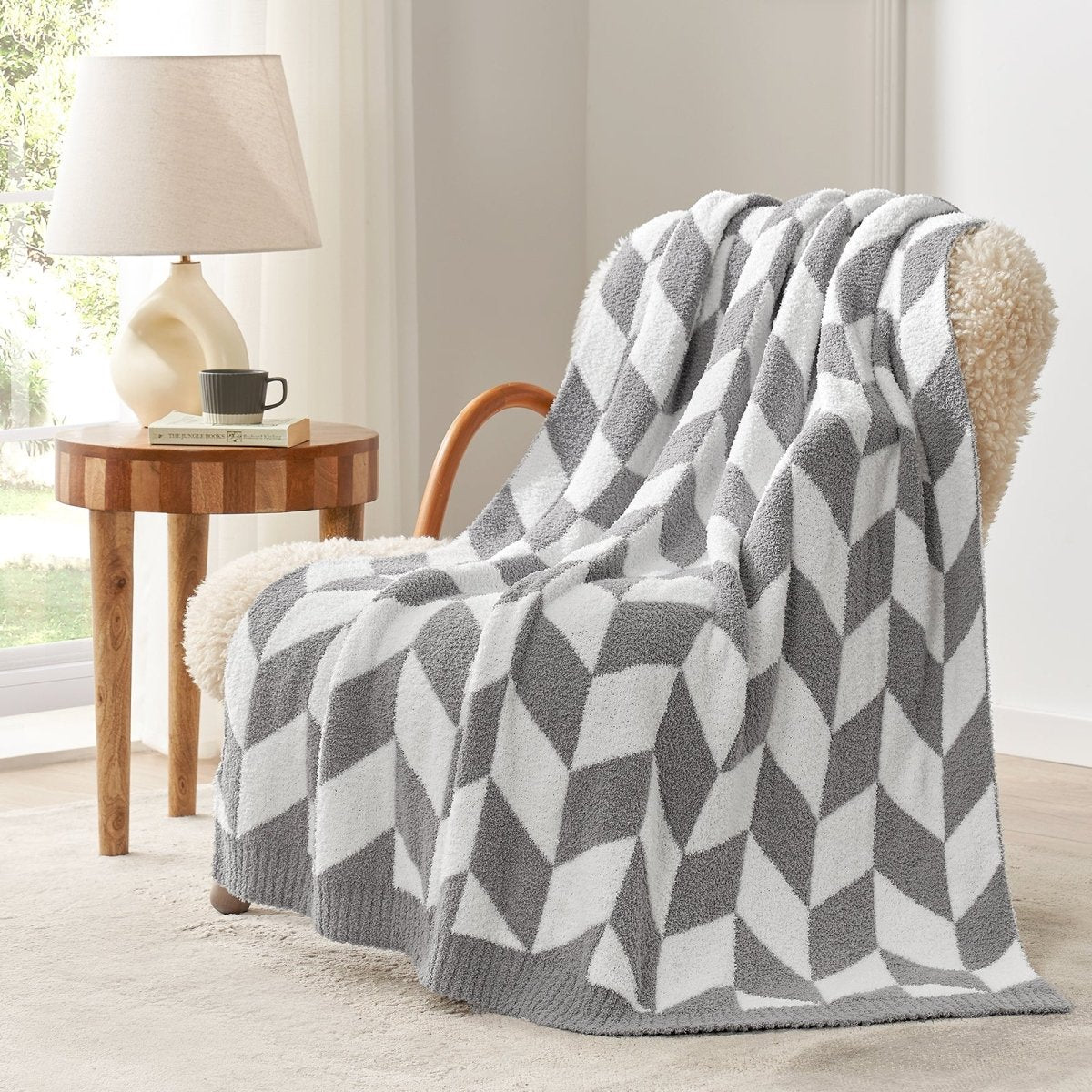 Chevron Feather Yarn Knit Throw Blanket in Grey draped over an armchair, showcasing soft feather yarn texture and chevron pattern design. #color_Grey