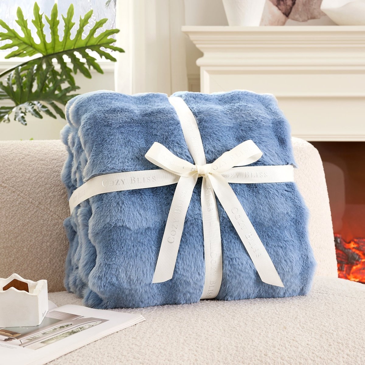 Fluffy misty blue blanket with a bow on a couch. #Color_ Misty Blue