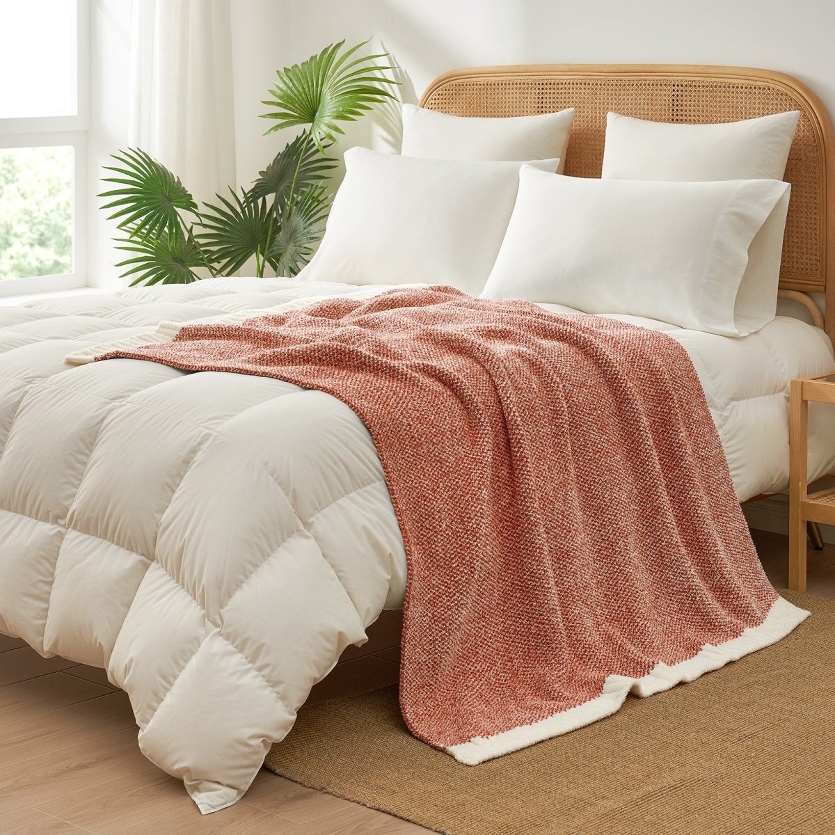 Heather Feather Yarn Throw Blanket in orange styled on a bed, enhancing bedroom decor with a soft, elegant and cozy layered look.  #Color_Orange