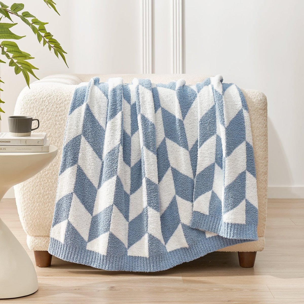 Chevron Feather Yarn Knit Throw Blanket in Blue draped over a sofa, showcasing soft texture and geometric chevron pattern design. #color_Blue