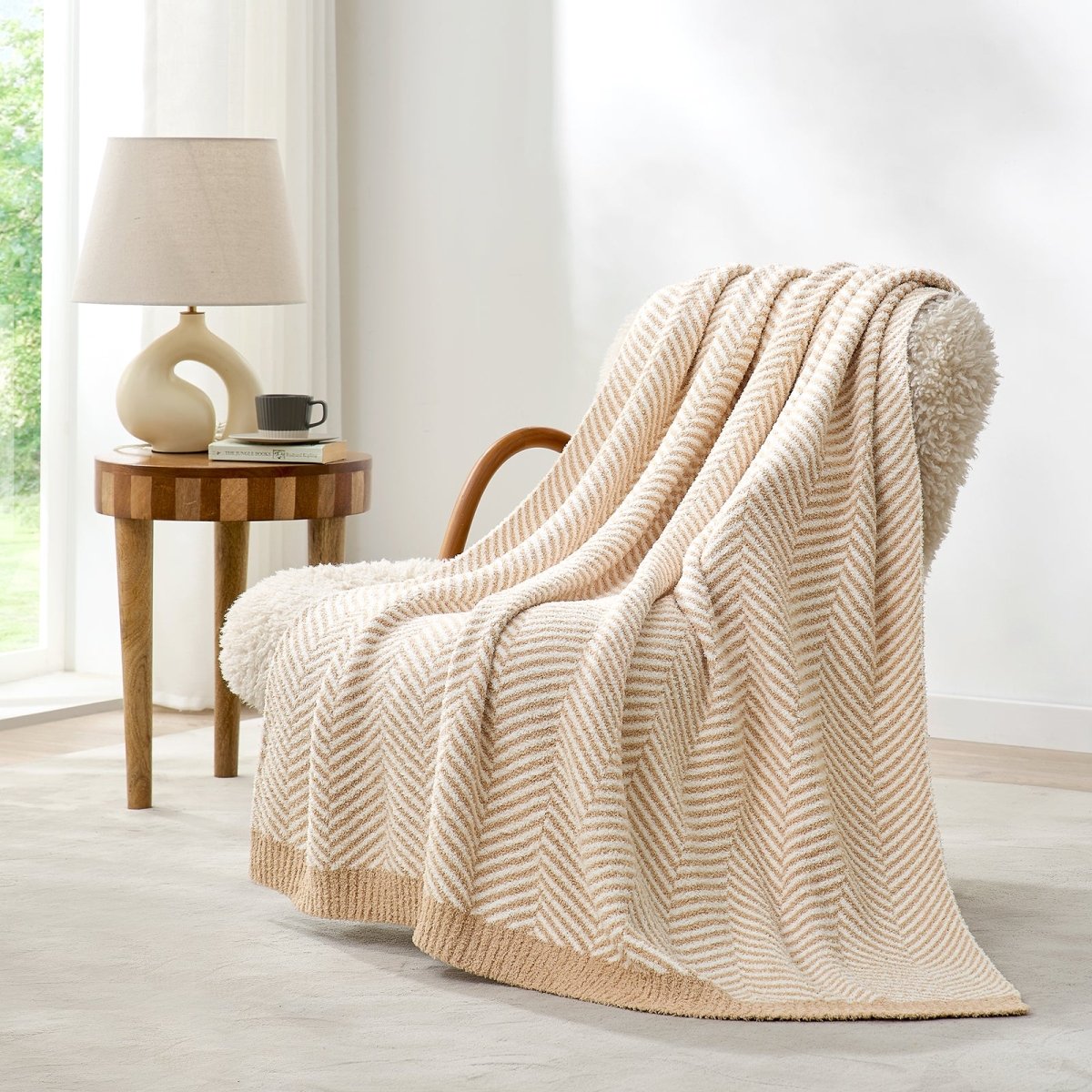 Reversible Herringbone Feather Yarn Knit Throw Blanket draped over a cozy accent chair beside a wooden side table #color_Beige