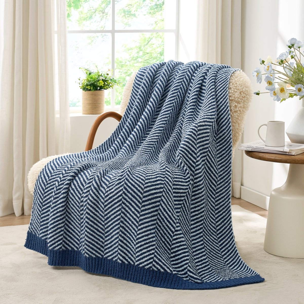 Reversible Herringbone Feather Yarn Knit Throw Blanket draped over a cozy accent chair beside a wooden side table #color_Navy Blue