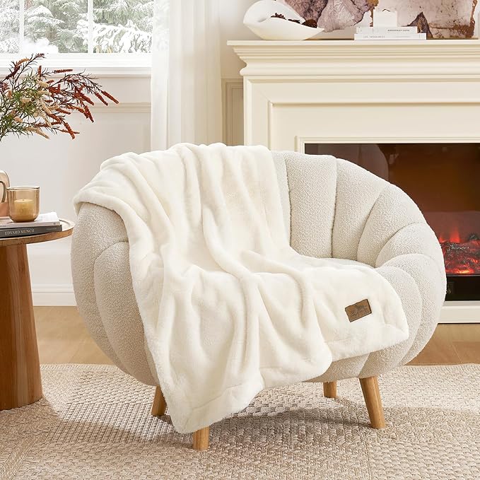 Cozy bliss leakproof faux fur pet blanket draped over an armchair in a cozy living room setting. #color_Cream White