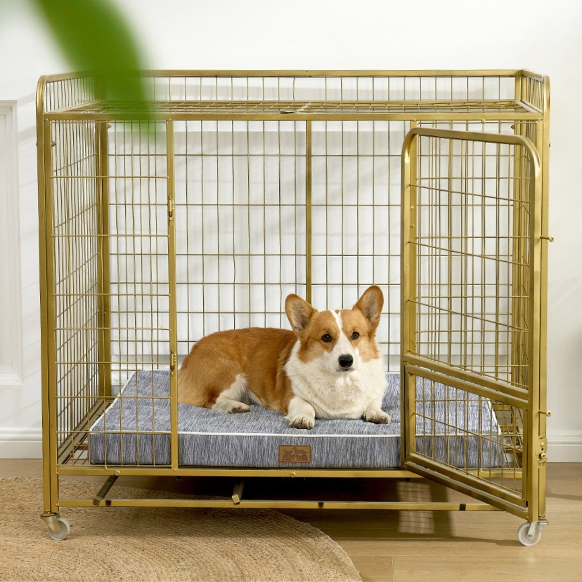 Dog lying on a cooling cushion inside a gold metal dog crate.#color_Grey