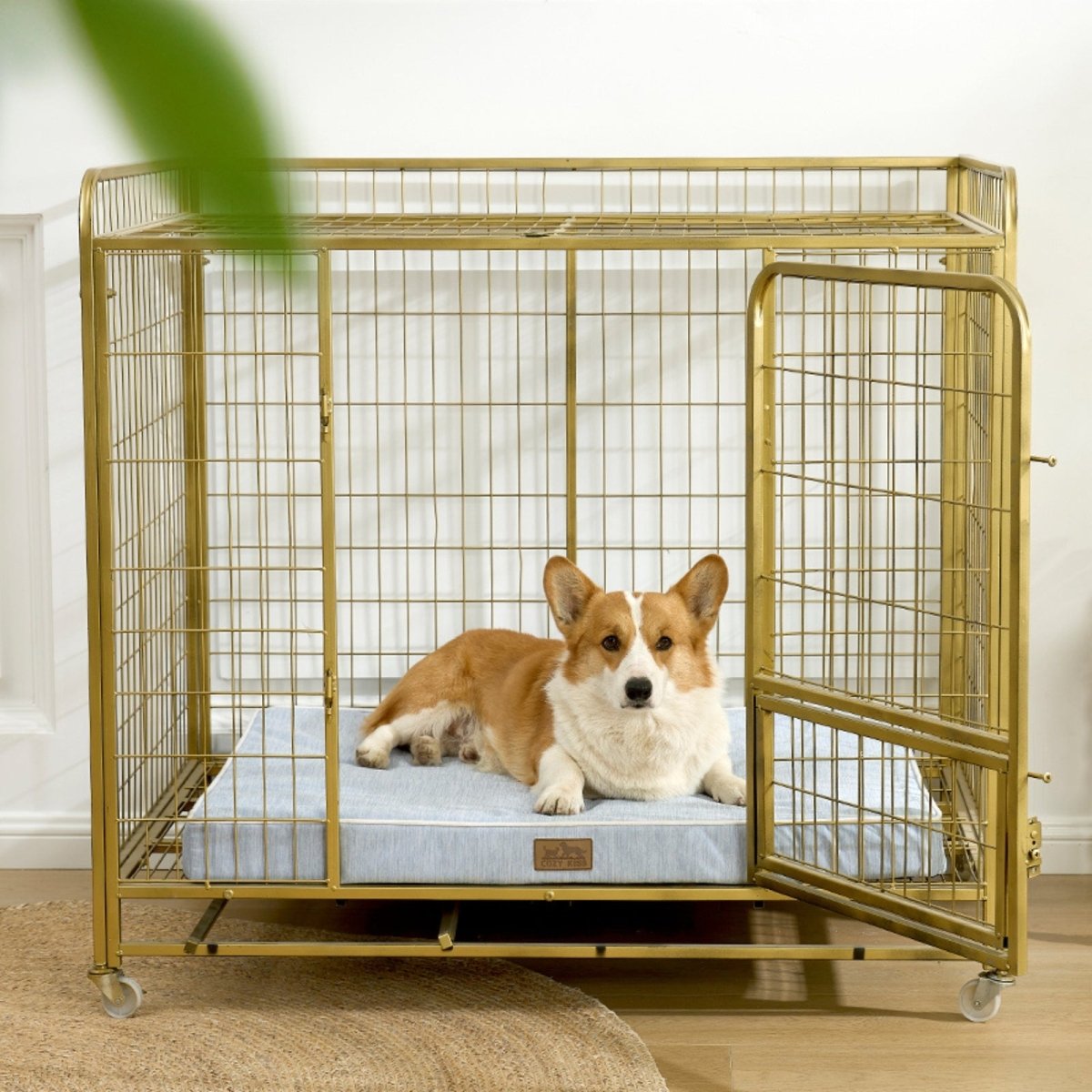 Dog lying on a cooling cushion inside a gold metal dog crate.#color_Cool Blue