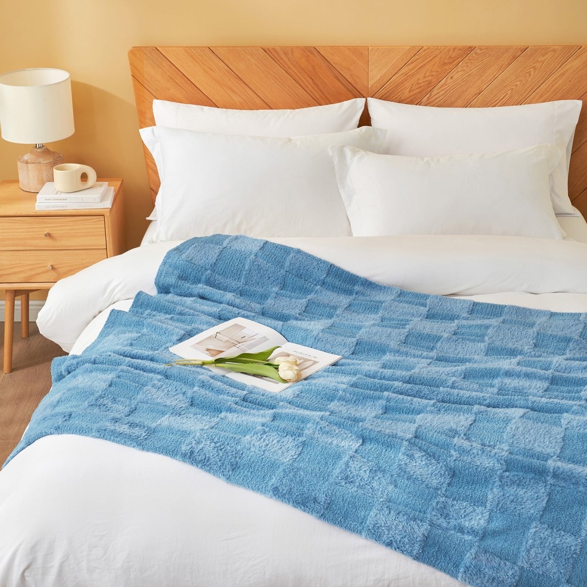Checkered Faux Fur Feather Yarn Throw Blanket in Blue styled on a bed, adding a cozy look. #color_Misty Blue