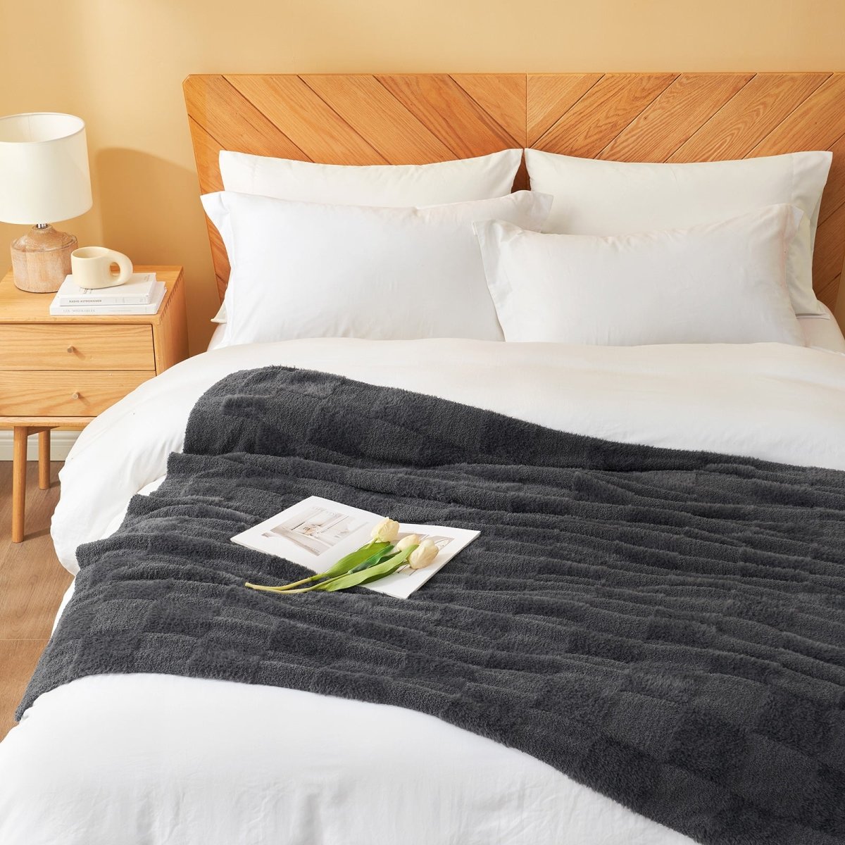Checkered Faux Fur Feather Yarn Throw Blanket in Dark Grey styled on a bed, adding a cozy touch. #color_Dark Grey