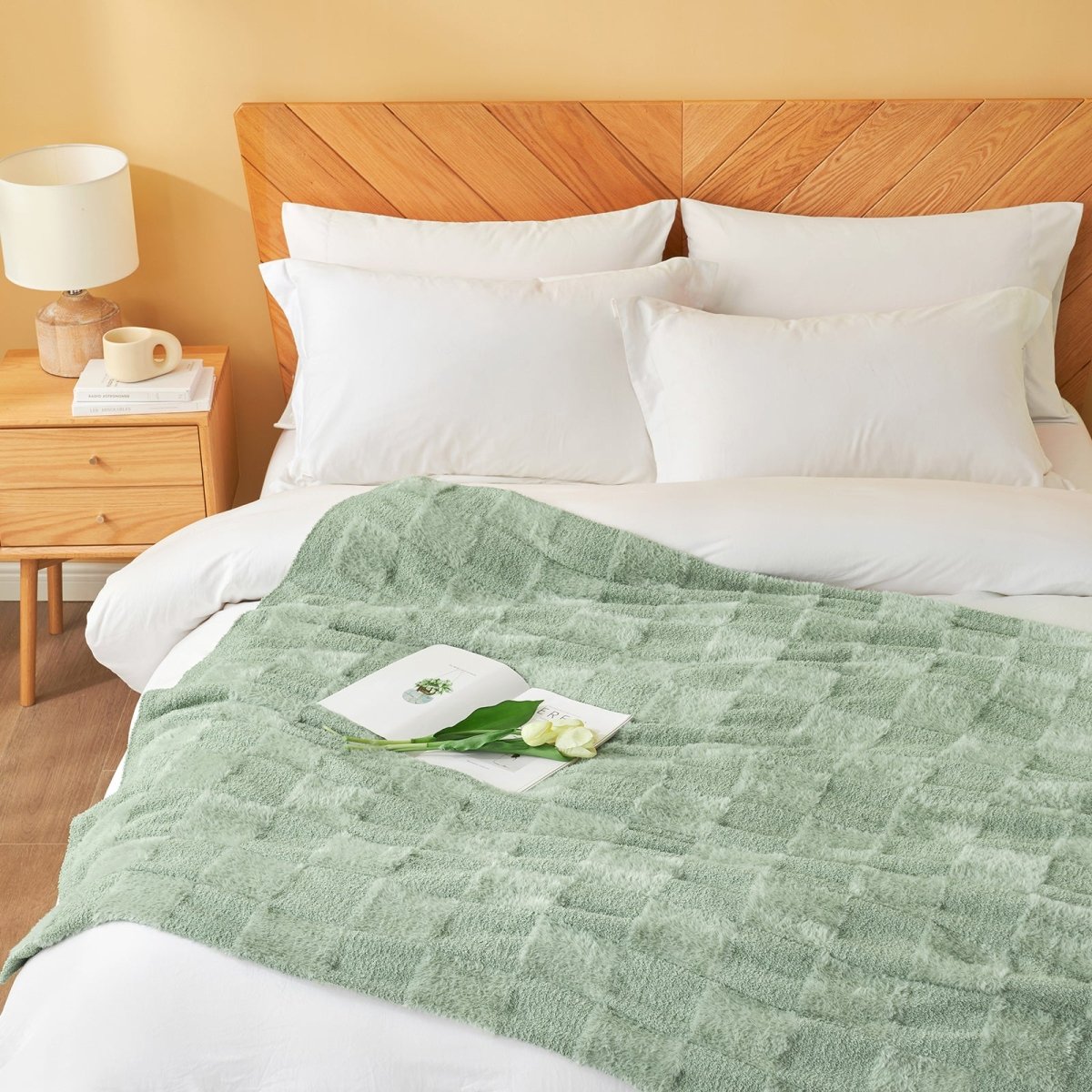 Checkered Faux Fur Feather Yarn Throw Blanket in Sage Green styled on a bed, creating a relaxing atmosphere. #color_Sage Green