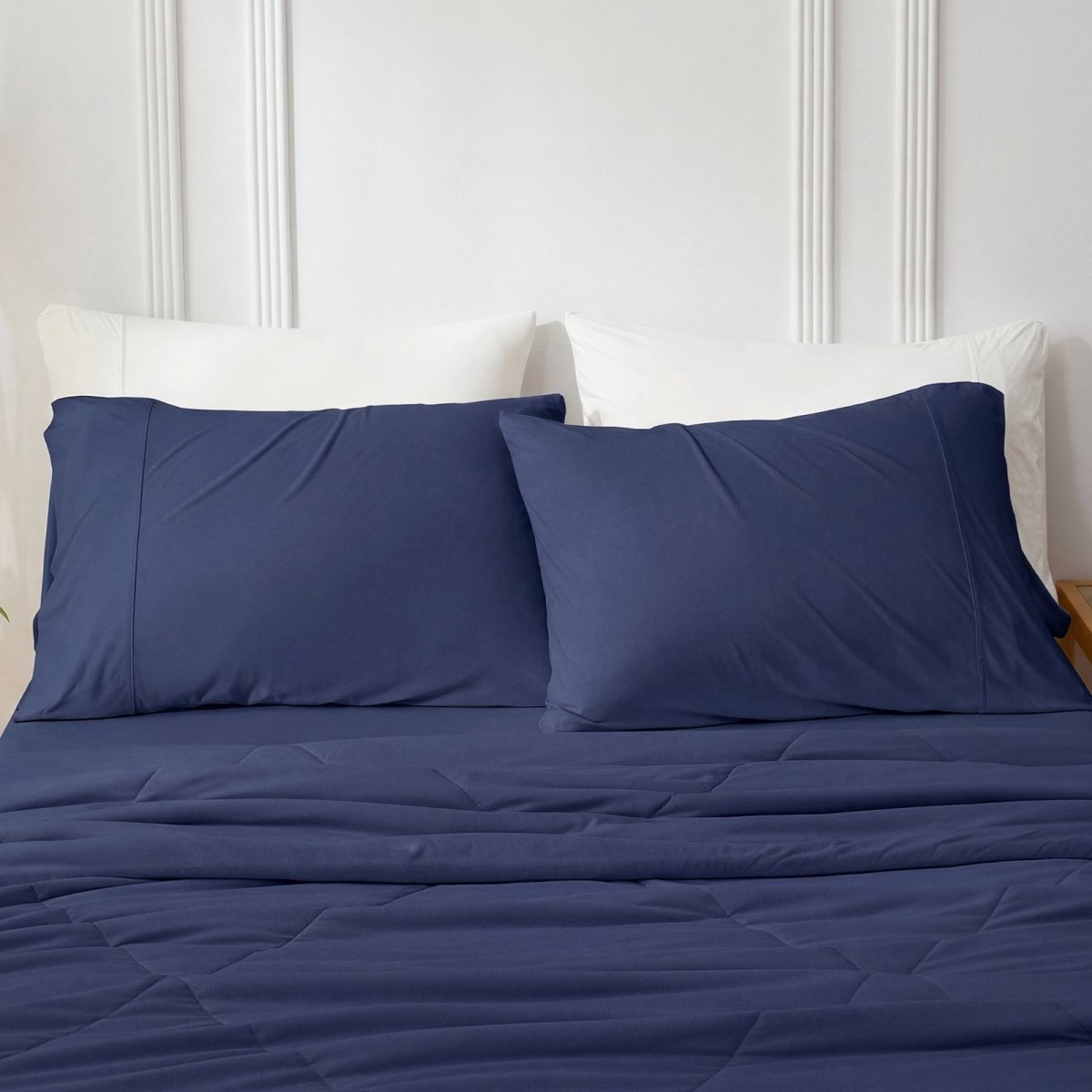 Navy blue cooling pillowcases on bed with cozy comforter.#color_Navy Blue