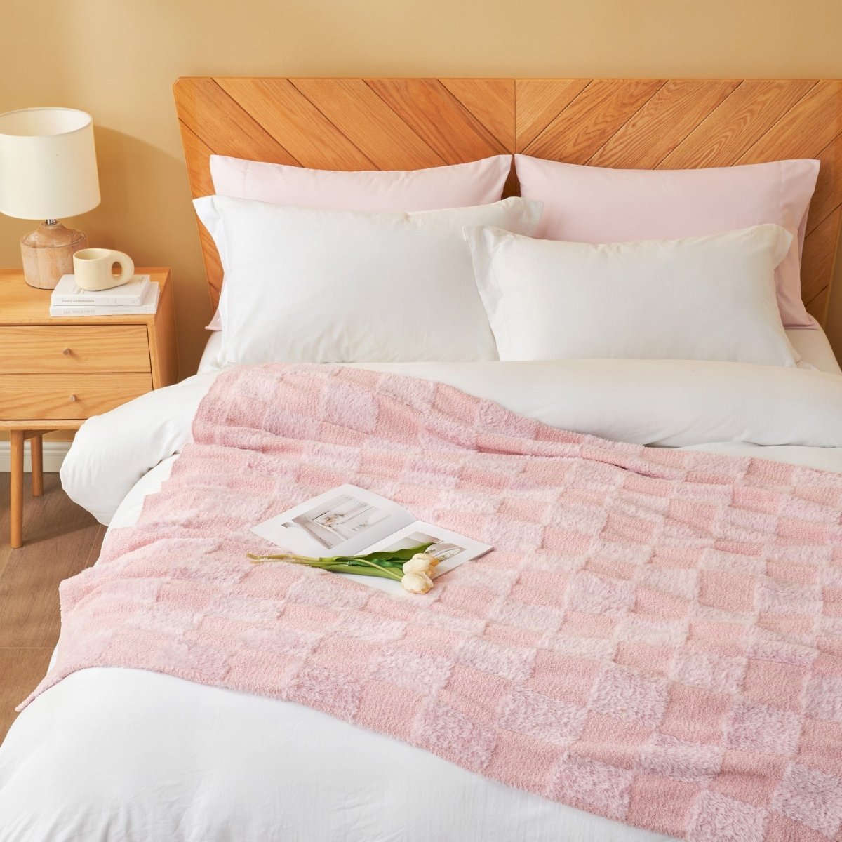 Checkered Faux Fur Feather Yarn Throw Blanket in Pink styled on a bed, adding a cozy and stylish look. #color_Pink