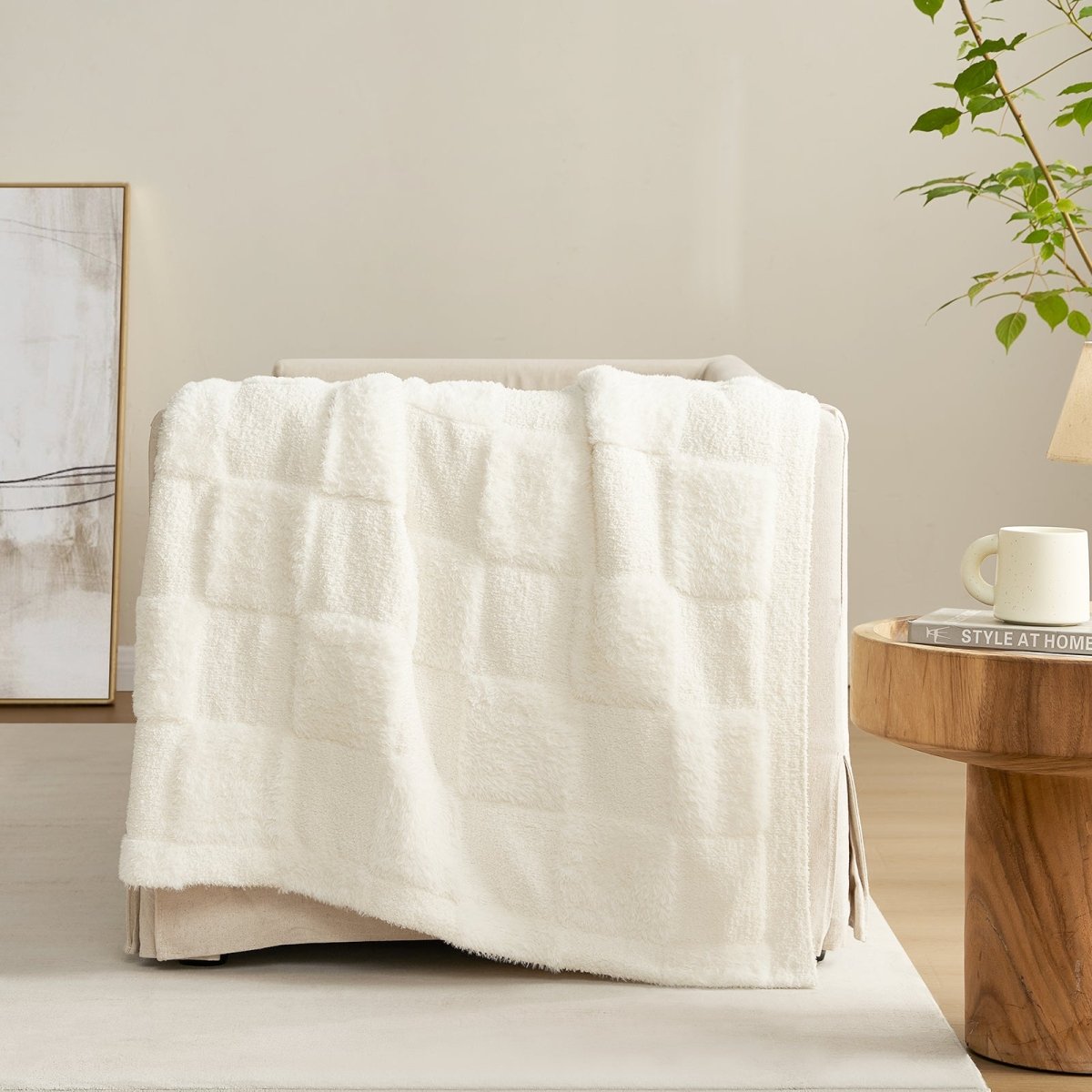 Checkered Faux Fur Feather Yarn Throw Blanket in Ivory draped over a sofa, highlighting its soft feel and subtle pattern. #color_Ivory