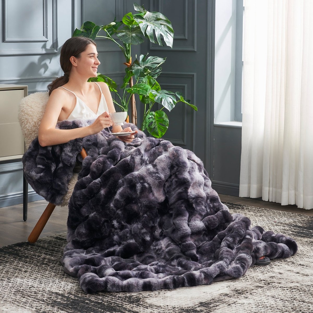 Women relaxing with tea while wearing Cozy Bliss tie-dye blank faux fur throw blanket #color_Tie-dye Black