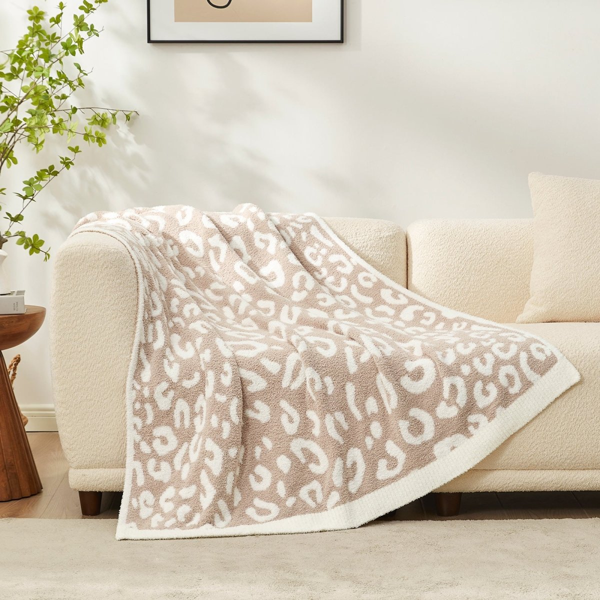 Reversible Leopard Feather Yarn Throw Blanket in Khaki Leopard draped over a sofa, highlighting its soft faux fur texture and modern pattern. #color_Khaki Leopard