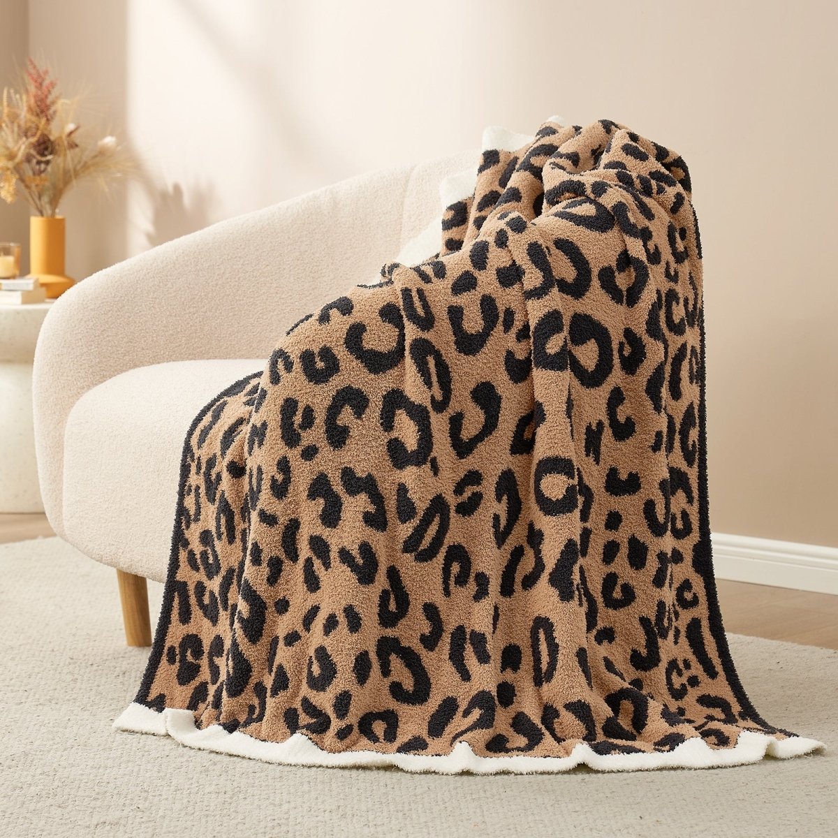 Reversible Leopard Feather Yarn Throw Blanket in Brown Leopard draped over an armchair, showcasing its bold leopard pattern and soft texture. #color_Brown Leopard