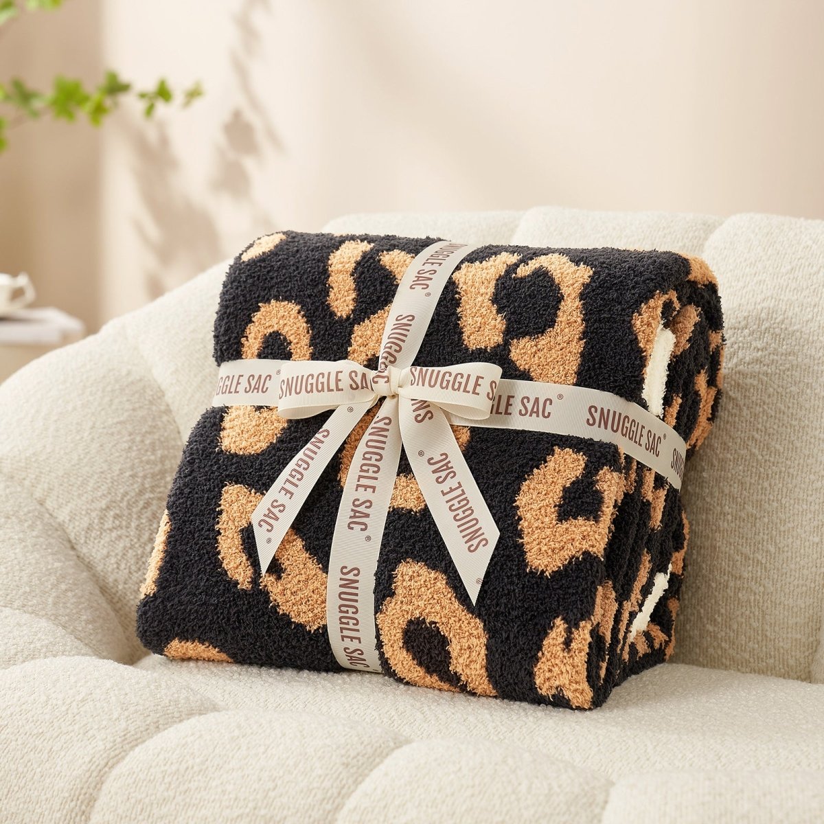 Reversible Leopard Feather Yarn Throw Blanket in Brown Leopard neatly folded with ribbon, perfect as a cozy gift option. #color_Brown Leopard