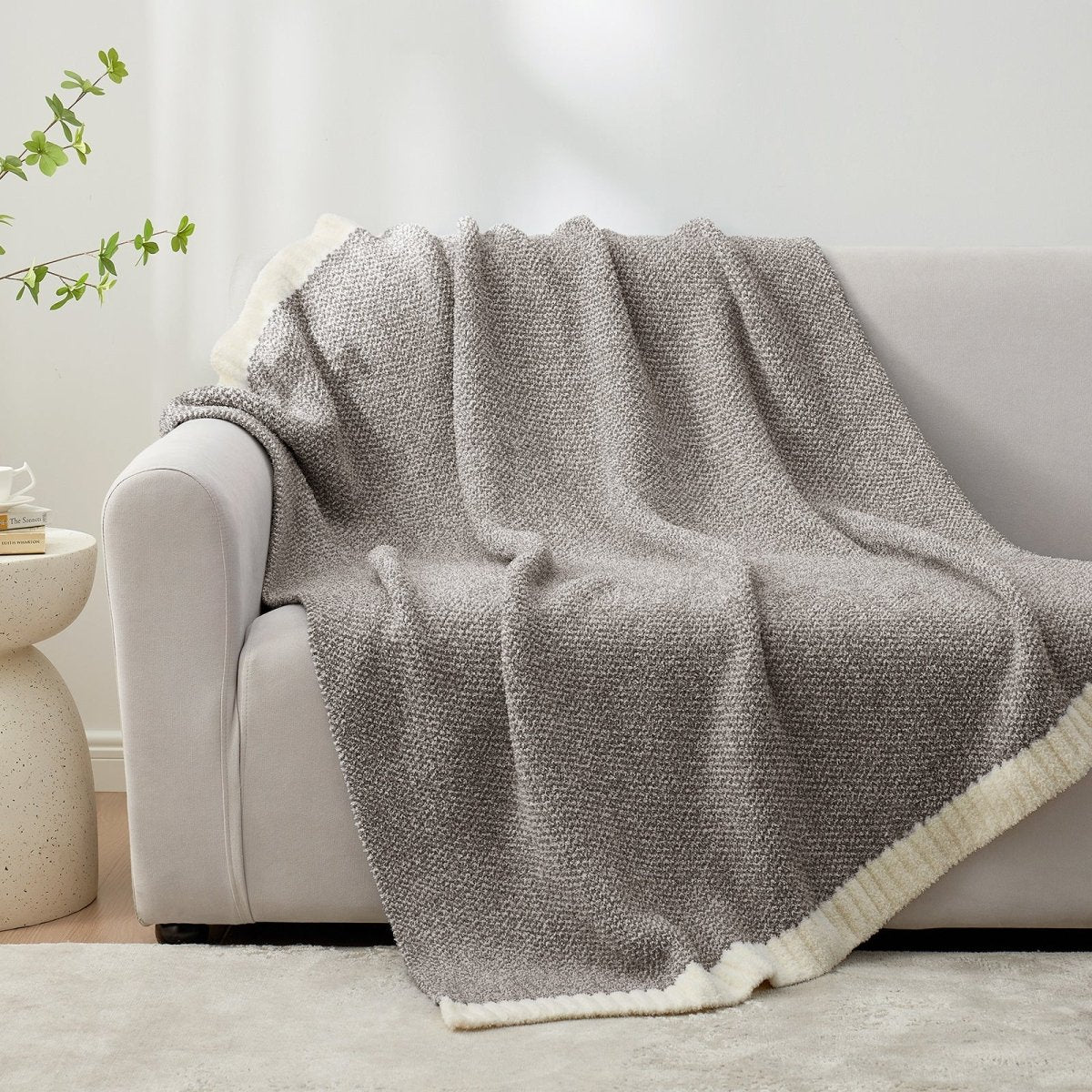 Heather Feather Yarn Throw Blanket in Dark Grey draped over a sofa, adding a modern and cozy touch. #color_Dark Grey