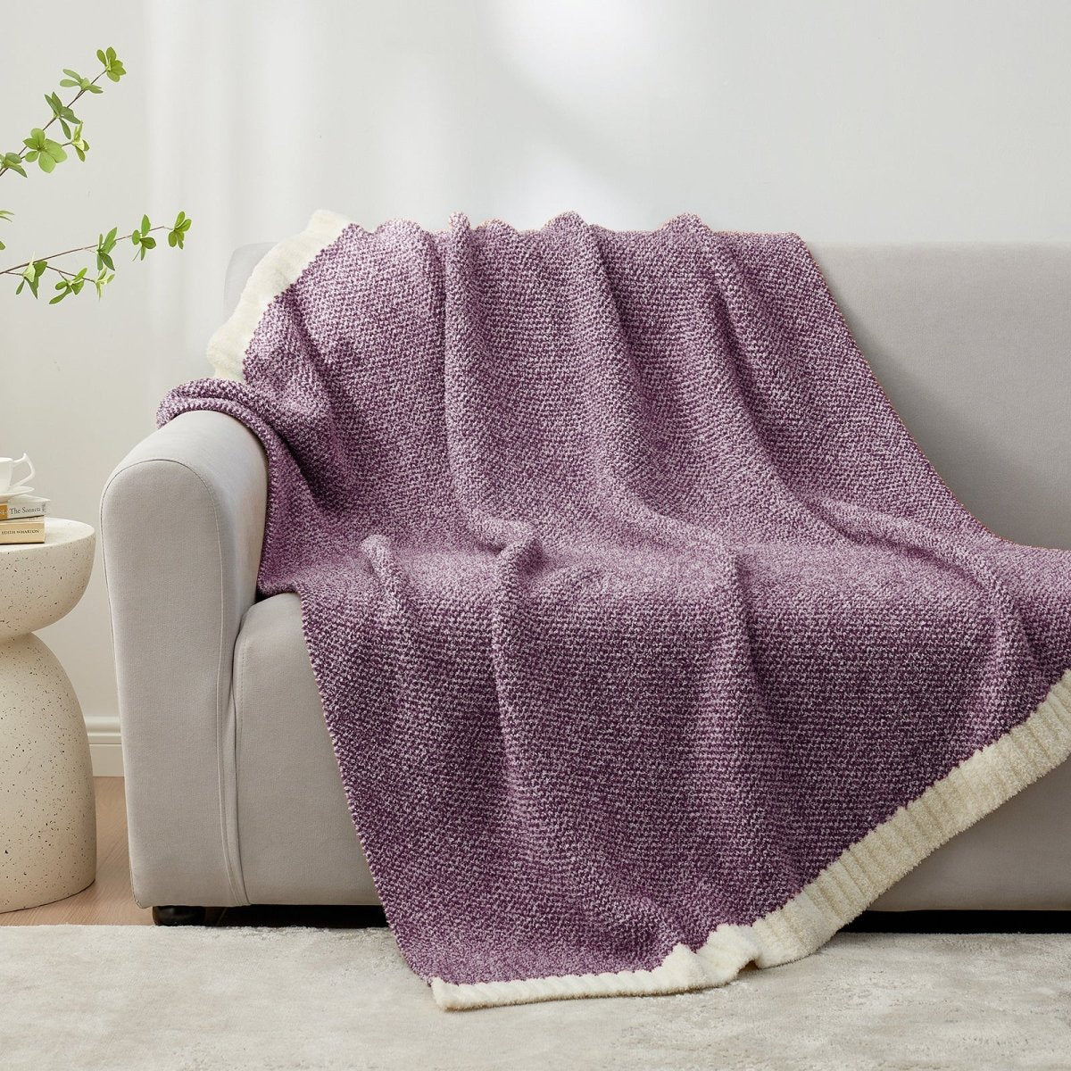 Heather Feather Yarn Throw Blanket in Lilac draped over a sofa, adding warmth and style. #color_Lilac