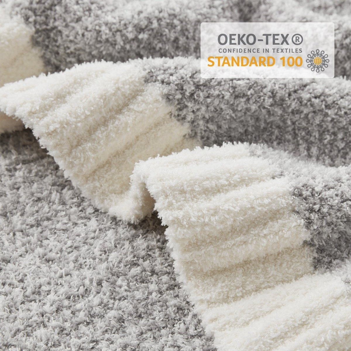 Close-up of Heather Feather Yarn Throw Blanket in Grey showcasing plush feather yarn texture and OEKO-TEX STANDARD 100 certification. #color_Grey
