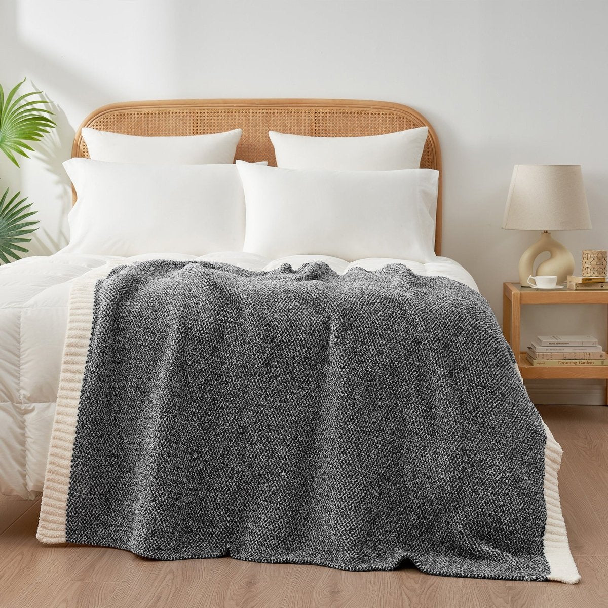 Heather Feather Yarn Throw Blanket in black styled on a bed, enhancing bedroom decor with a soft, elegant and cozy layered look. #Color_Black