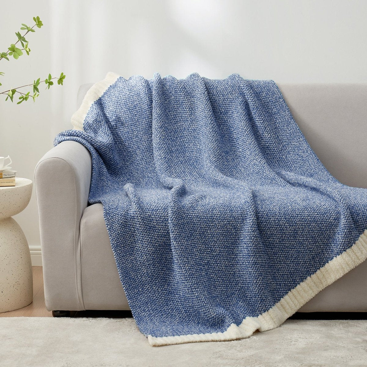 Heather Feather Yarn Throw Blanket in Dark Blue draped over a sofa, adding a rich and cozy touch. #color_Dark Blue