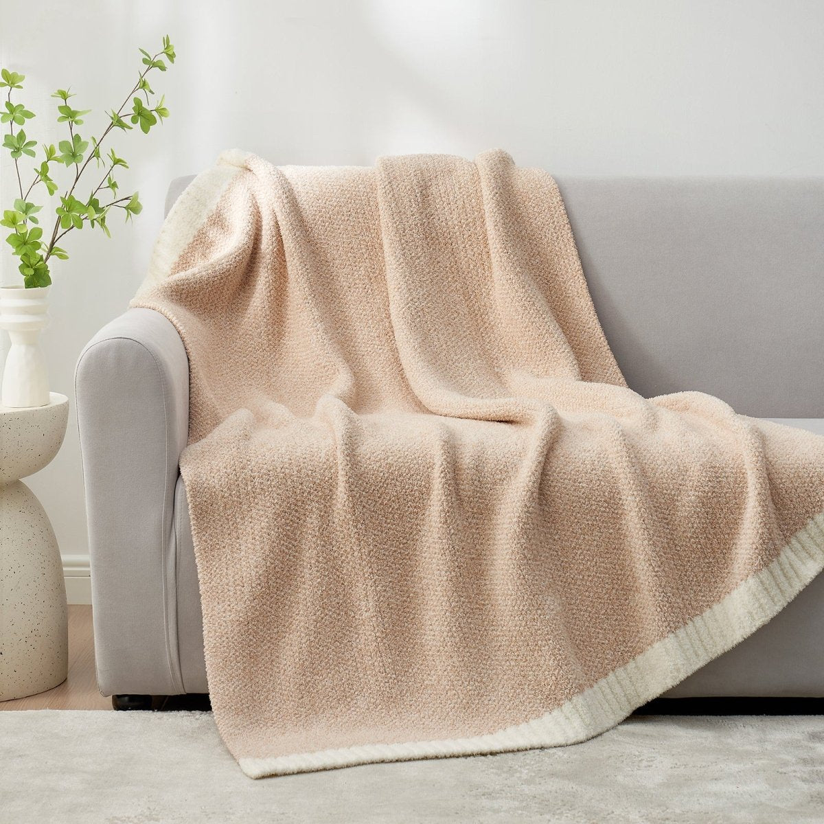 Heather Feather Yarn Throw Blanket in beige draped over a sofa, adding warmth, softness and a modern cozy touch to your living room.  #color_Beige