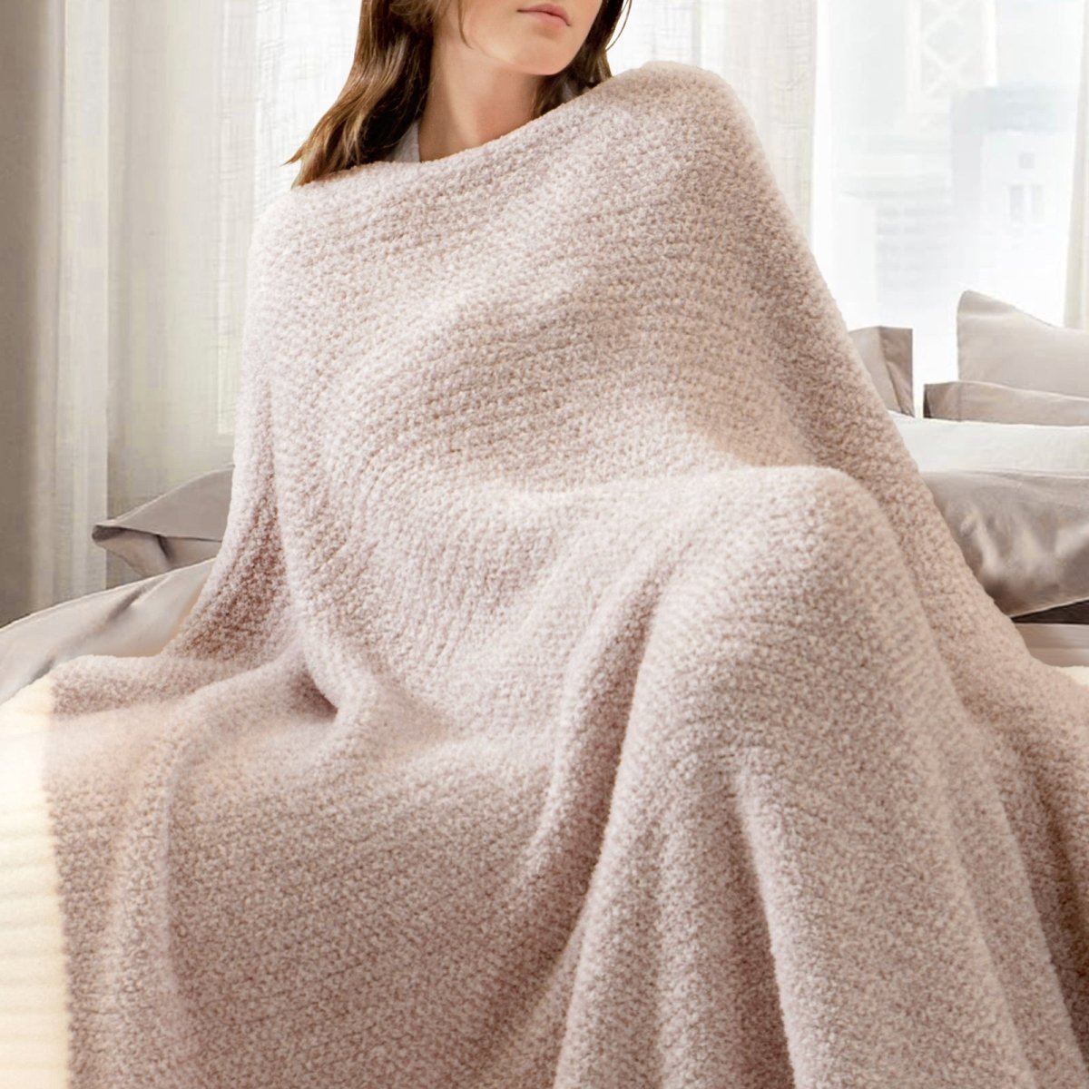 Woman wrapped in a Heather Feather Yarn Throw Blanket in brown, relaxing comfortably. #Color_Light Brown