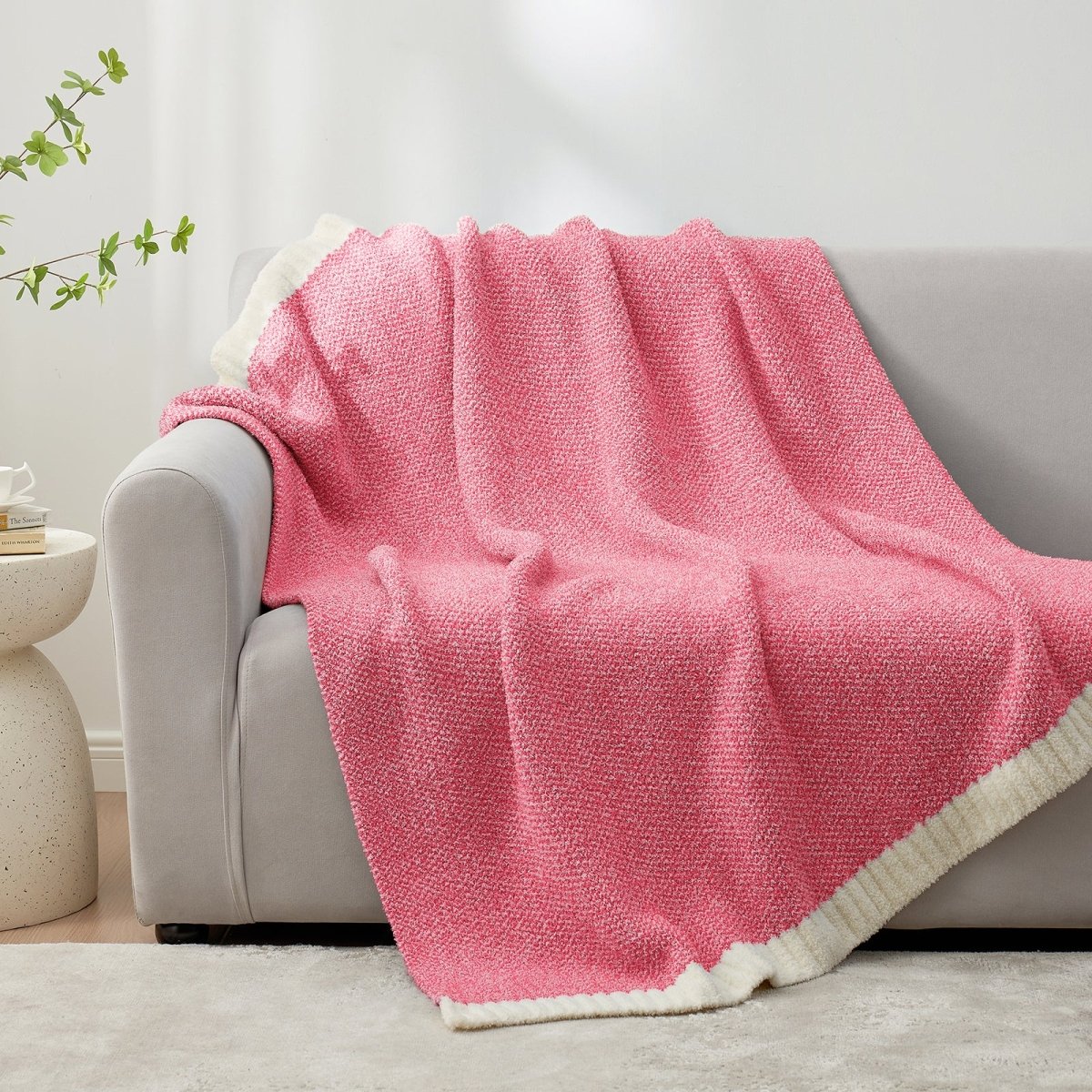 Heather Feather Yarn Throw Blanket in Hot Pink draped over a sofa, adding warmth and vibrant style. #color_Hot Pink