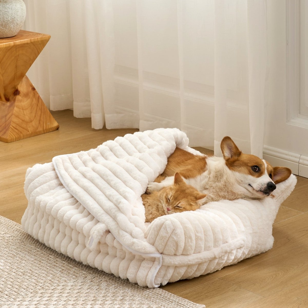  Corgi and Cat, lying on a fluffy white faux fur pet bed in a cozy room.#color_Cream White