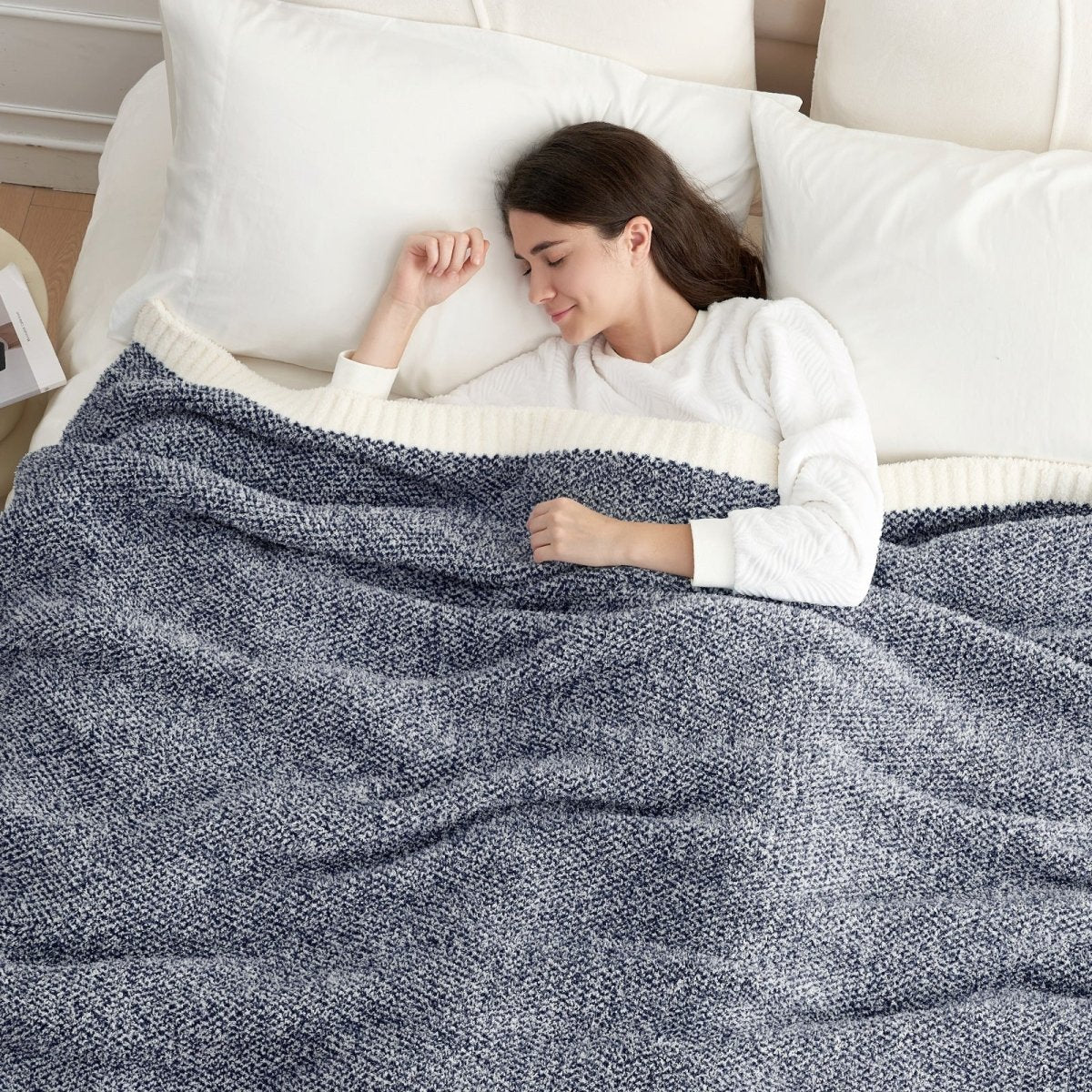 Woman sleeping under a Heather Feather Yarn Throw Blanket in Navy Blue, providing cozy warmth. #color_Navy Blue