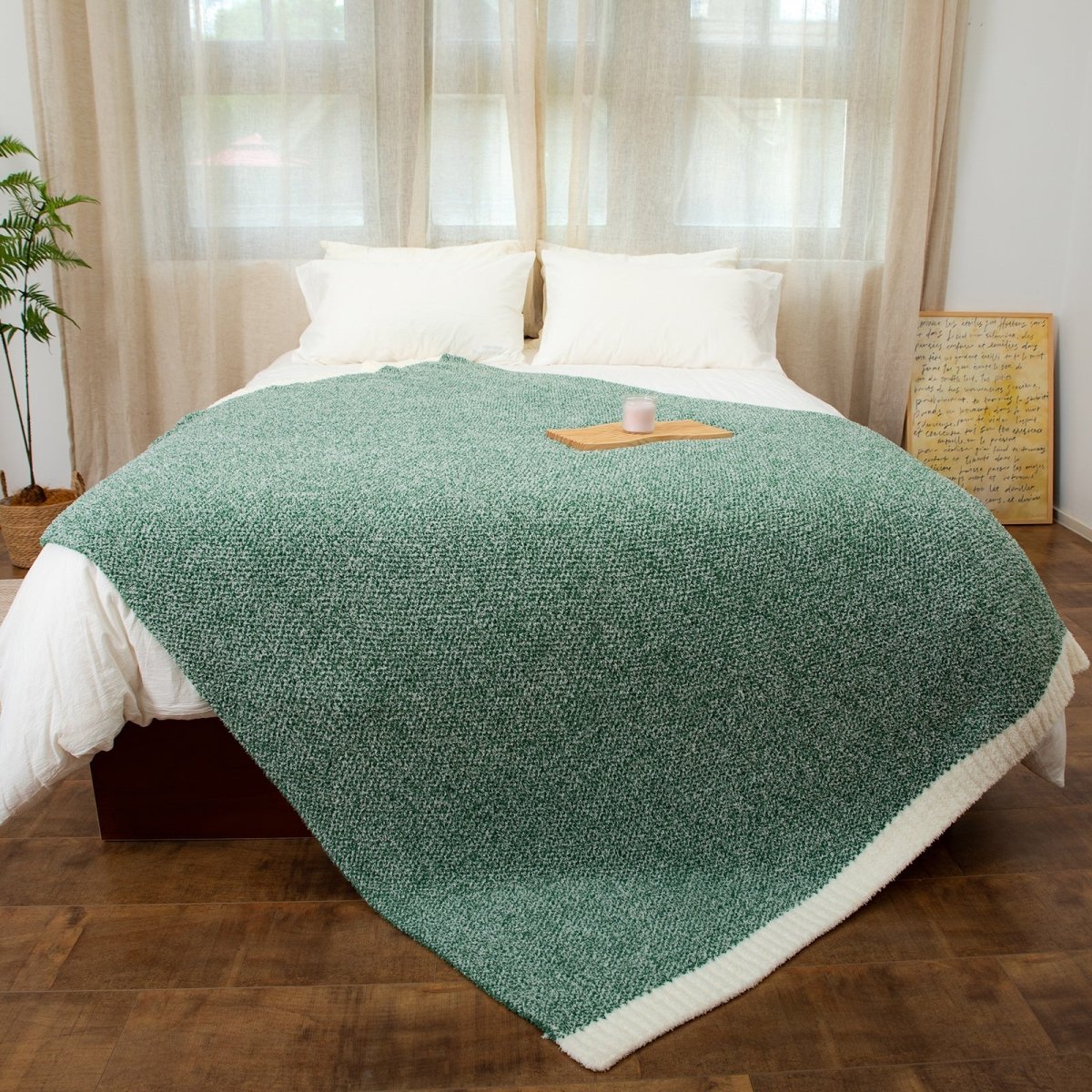 Heather Feather Yarn Throw Blanket in heather green styled on a bed, enhancing bedroom decor with a soft, elegant and cozy layered look.  #Color_Heather Green